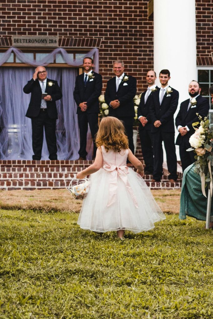 Hochzeit mit Kindern: Blumenmädchen mit Körbchen läuft vor dem Brautpaar zur Trauung