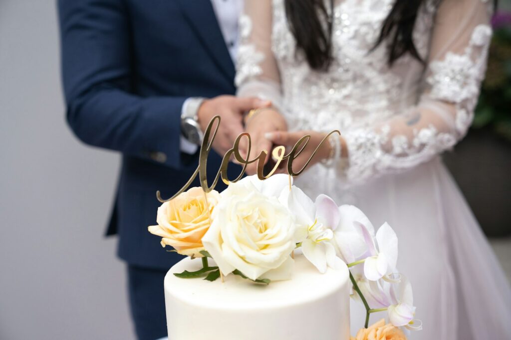 Brautpaar beim Anschneiden der Hochzeitstorte mit einem gemeinsamen Messer