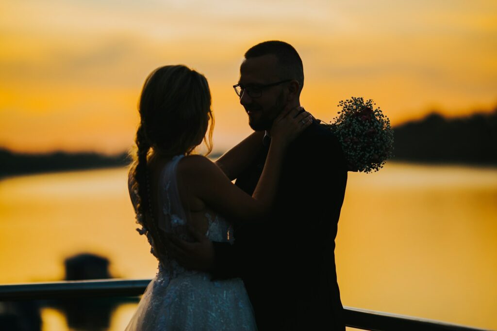 Brautpaar im Abendlicht auf einer Wiese, eines der schönsten Hochzeitsfotos Ideen für die goldene Stunde