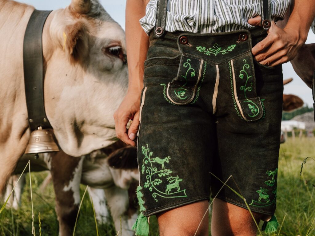 Brautpaar in Dirndl und Lederhose vor einer Hochzeitslocation Bayern auf dem Land