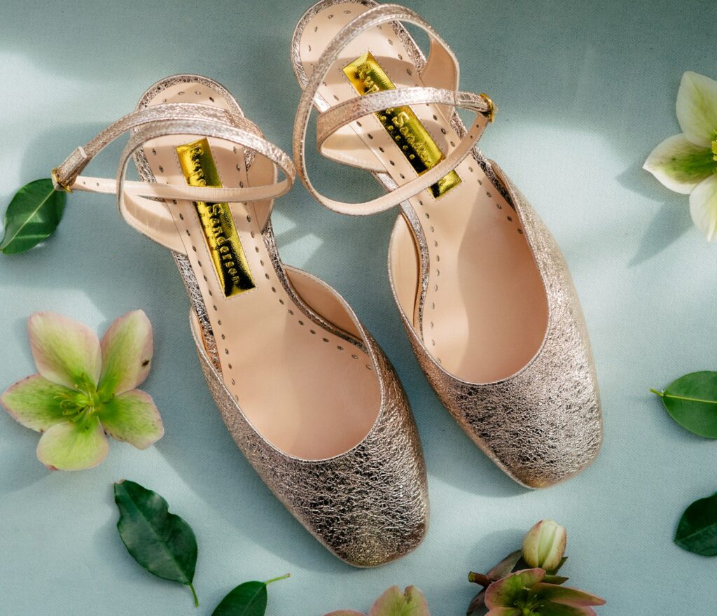 Brautschuhe mit Blockabsatz: Satin-Pumps in Elfenbein auf einem Holzboden