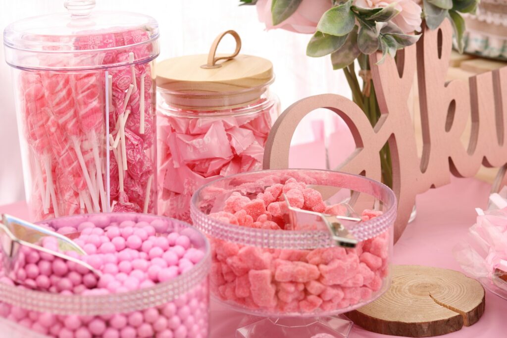 Candybar Hochzeit mit Bonbongläsern, Etageren und pastellfarbenen Süßigkeiten auf einem Holztisch