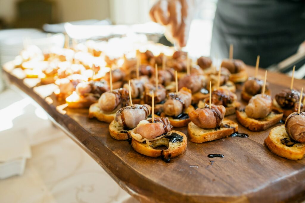 Fingerfood auf einem Tablett beim Sektempfang Hochzeit: Crostini, Gemüsesticks und Mini-Quiches