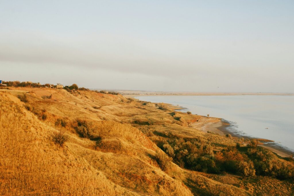 Flitterwochen Herbst: Brautpaar spaziert bei warmem Abendlicht an einem ruhigen Strand