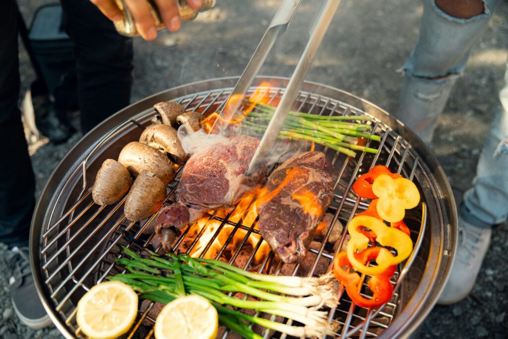 Freunde stehen am Grill, ein Grillkurs gehört zu den entspannten JGA Ideen Männer