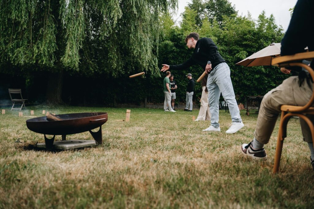 Gäste spielen beim Sektempfang Hochzeit im Garten ein Rasenspiel