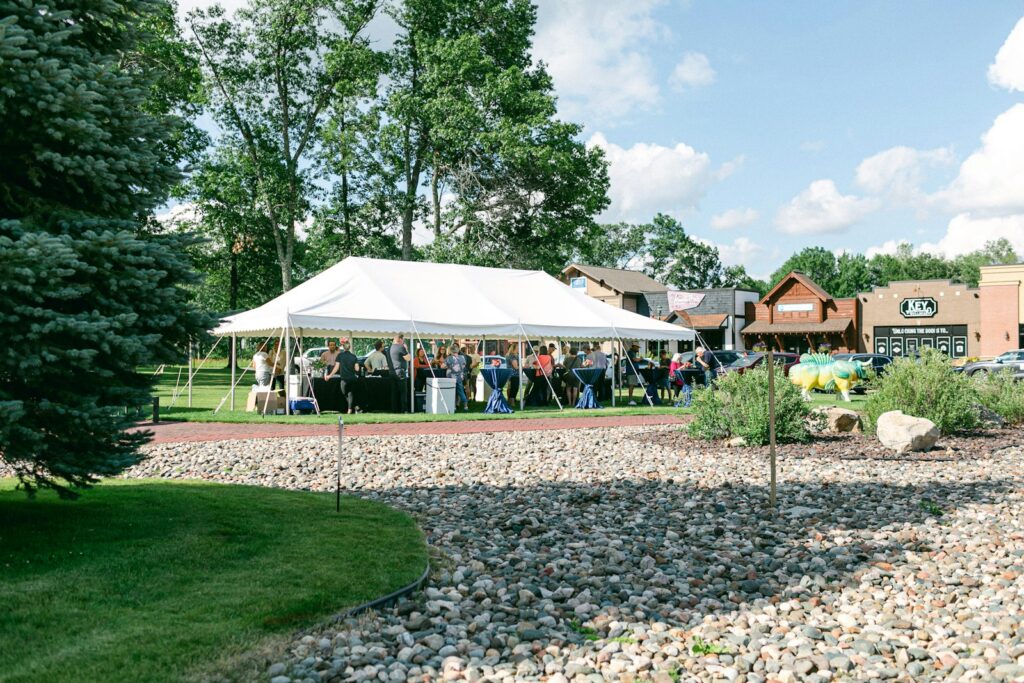 Gedeckte Tafeln mit Kerzenlicht unter einem Zeltdach bei einer Hochzeit im Zelt