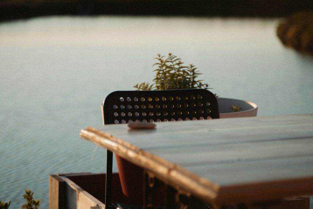 Hochzeit am See: gedeckte Tafel am Ufer mit Lichterketten am Abend