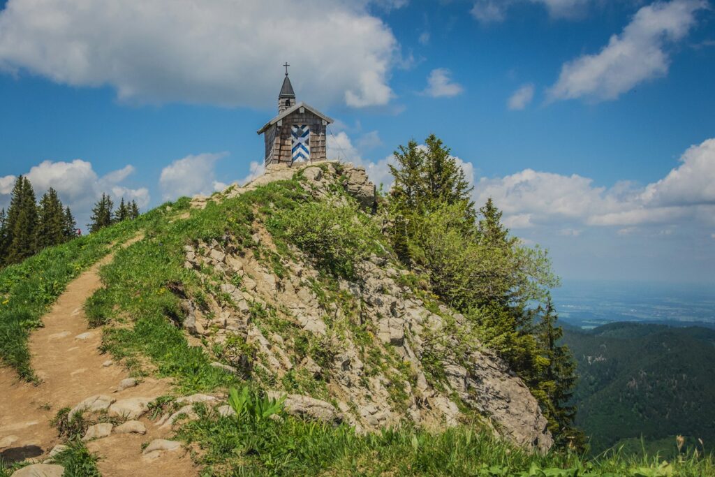 Hochzeitslocation Bayern: kleine Bergkapelle vor Alpenpanorama an einem Sommertag