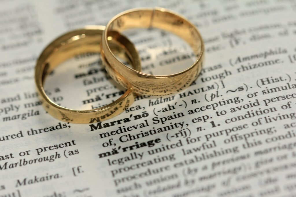 Kirchlich heiraten ohne Standesamt: Eheringe liegen auf einer aufgeschlagenen Bibel