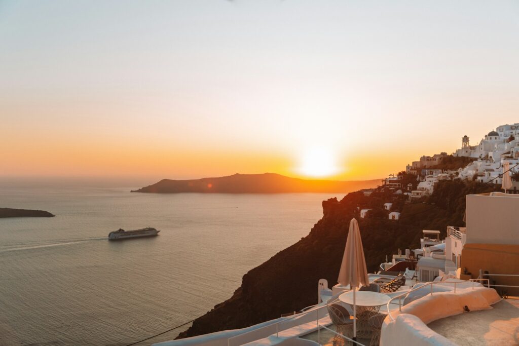Paar blickt bei Sonnenuntergang auf die Caldera von Santorini, Flitterwochen Griechenland