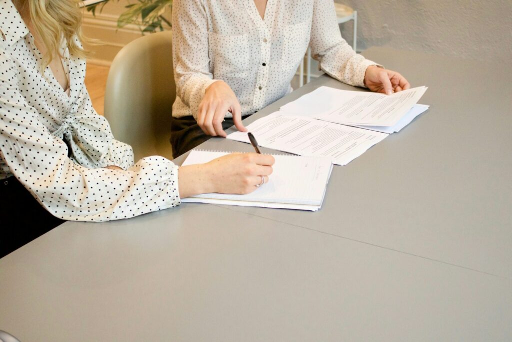 Paar unterschreibt gemeinsam einen Ehevertrag am Tisch vor der Hochzeit