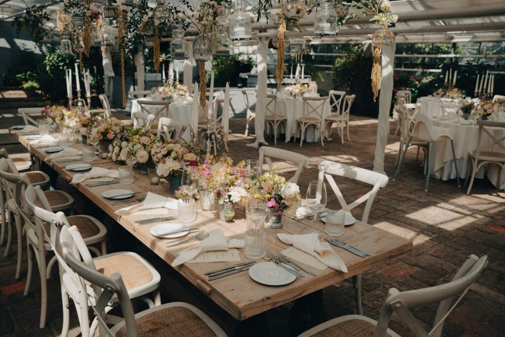 Rustikale Tischdeko für die Hochzeit Scheune mit Holz, Wiesenblumen und Kerzen in Gläsern