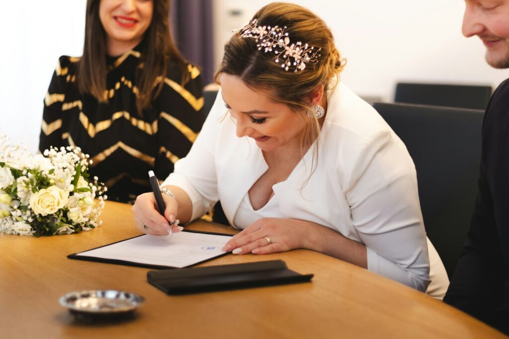 Unterlagen Standesamt Hochzeit: Ausweise, Urkunden und Eheringe liegen auf einem Holztisch