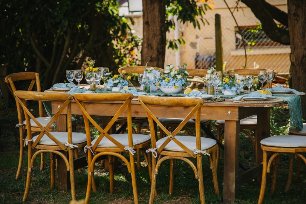 Tischdeko Hochzeit mit Wiesenblumen in kleinen Glasvasen auf einer Sommertafel